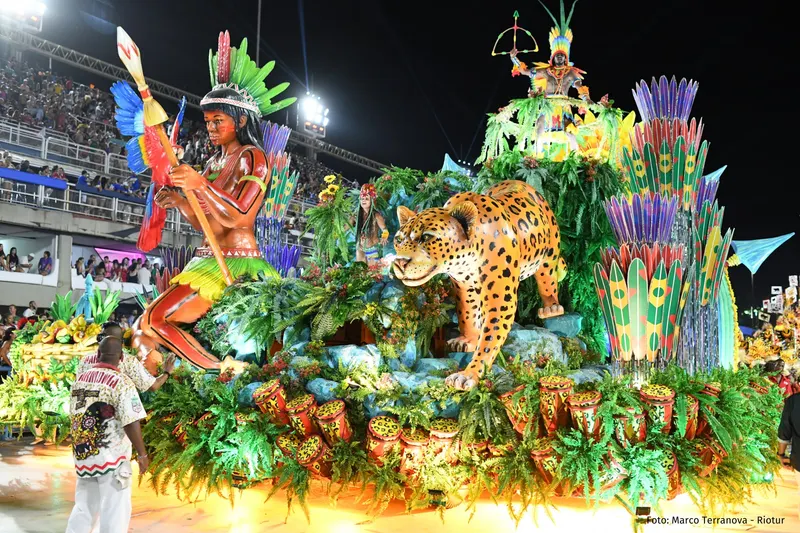 Rainforest-themed float with a giant jaguar sculpture and a warrior figure